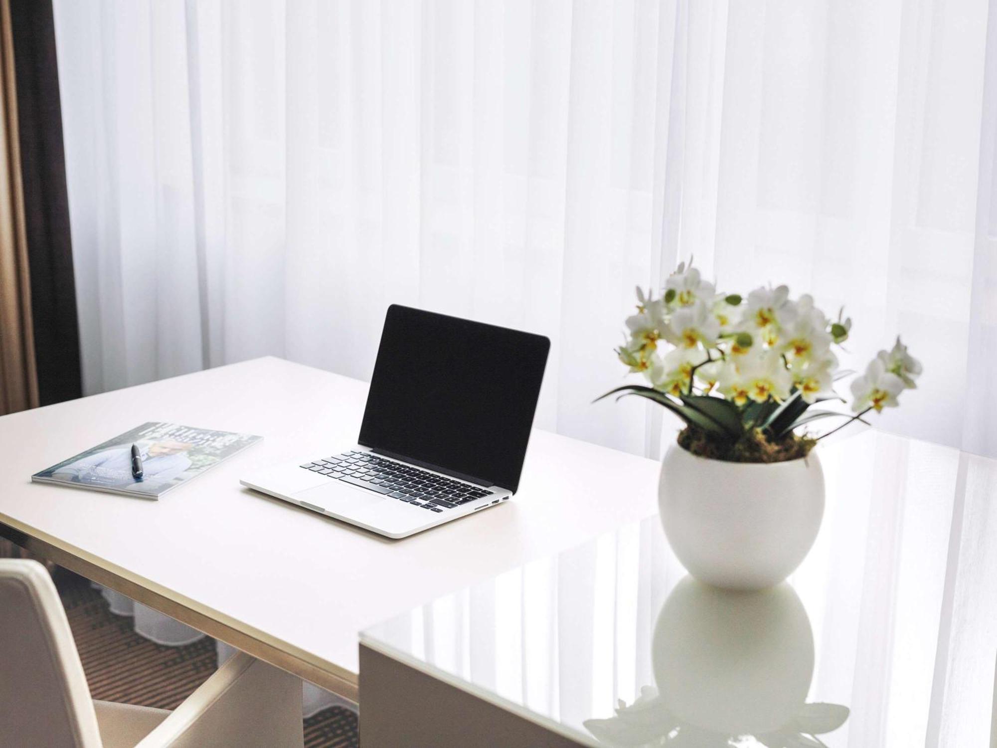 Pullman Berlin Schweizerhof Hotel Ngoại thất bức ảnh A desk with a laptop and a vase of flowers